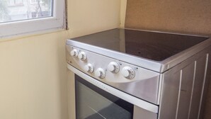 Forno de aço inoxidável com quatro botões e porta de vidro.