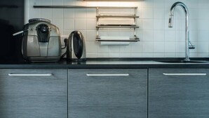 A kitchen with a coffee maker, a kettle, a sink, and a towel rack. - Apartment (Minsk)