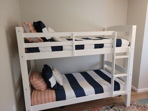 A bunk bed with two levels, each with a mattress and pillows.
