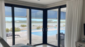 Camera da letto con un'ampia porta scorrevole in vetro che dà su una zona piscina.