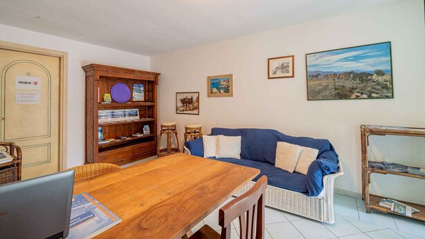 Ein gemütliches Wohnzimmer mit einem Holzesstisch, einem blauen Sofa und einem Bücherregal.