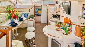 A compact galley with a dining area, a small kitchenette, and a seating arrangement. - Palm House (Grenadines)