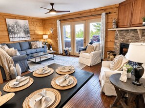 A cozy living room with a sofa, armchairs, a coffee table, and a fireplace.