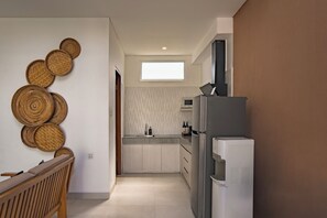 A modern kitchen with a built-in oven, a refrigerator, and a window above the sink. - Aeera Villa Canggu by Ini Vie Hospitality (Canggu)
