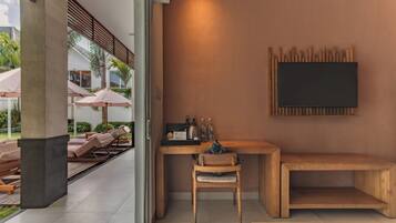 Una habitación moderna con un escritorio de madera, una silla, un banco y un televisor montado.
