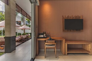 A modern room with a wooden desk, a chair, a bench, and a mounted television. - Aeera Villa Canggu by Ini Vie Hospitality (Canggu)