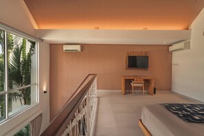 Un dormitorio moderno con un ventanal grande, un escritorio, una cama y un equipo de aire acondicionado.