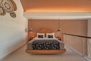 A bedroom with a bed suspended from the ceiling, a wooden headboard, bedside tables, and a view of the balcony. - Aeera Villa Canggu by Ini Vie Hospitality (Canggu)