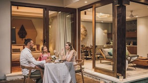 A family dining at a table with a view of a pool and indoor seating area.