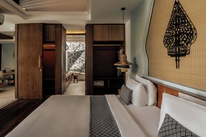 Una habitación de hotel moderna con una cama grande, un armario, un tocador con espejo y una lámpara colgante.