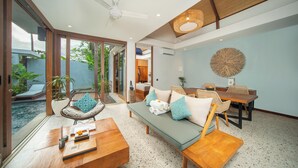 Uma sala de estar moderna com sofá, cadeiras, mesa de centro e um espaço de jantar com mesa e cadeiras.