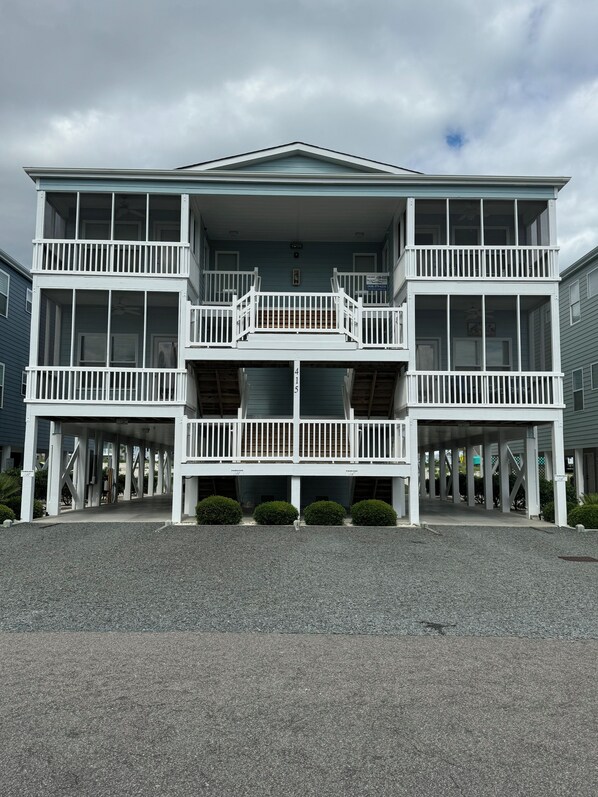 A multi-story building with a covered entrance and balconies.
