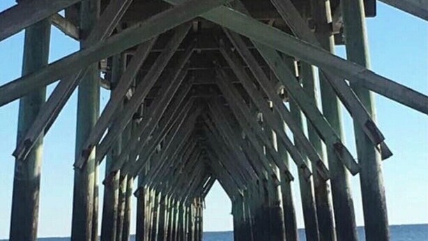 A pier structure with a concrete walkway leading to the water.