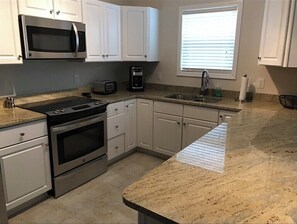 Enjoy cooking in this well-equipped kitchen with a window and stainless steel appliances.