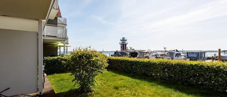 Un balcón con vista a un faro y barcos.