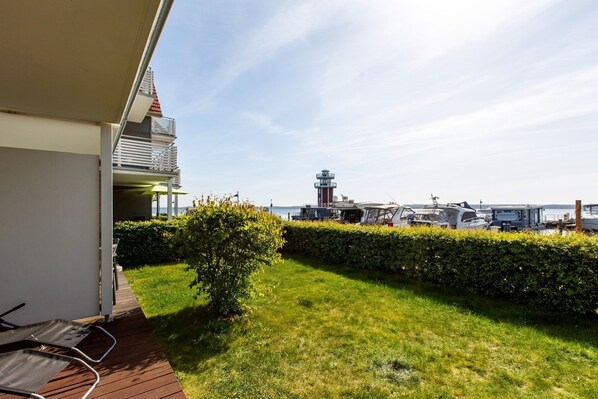 A balcony with a view of a lighthouse and boats.