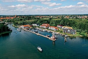 A riverside town with a marina, houses, and a church.