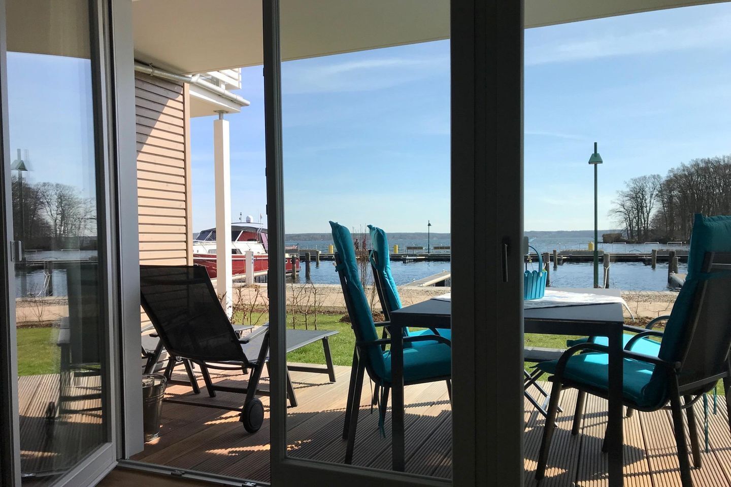 A deck with outdoor seating and a view of a marina.