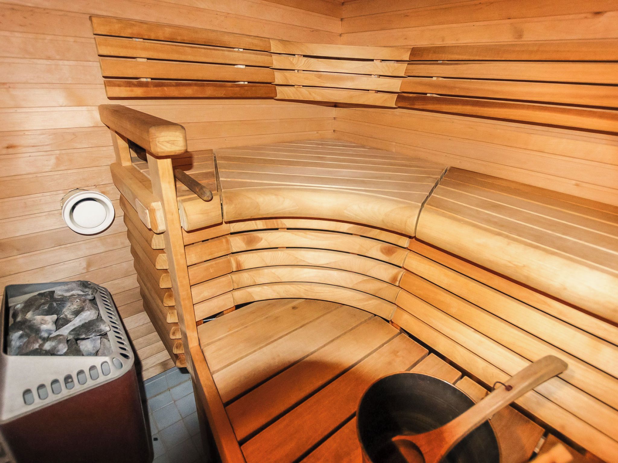 A sauna with wooden benches and a steam generator.