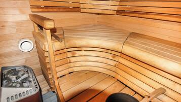 A sauna with wooden benches and a steam generator.