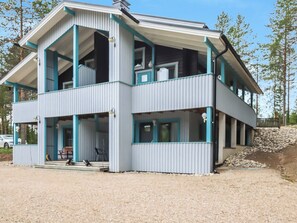 Een gebouw met twee verdiepingen, een balkon op de bovenverdieping en een overdekte veranda op de begane grond.