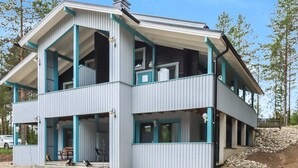 A two-story building with a flat roof and a balcony on the upper floor. - Taukotuli 4 paritalon alakerta by Interhome (Hyrynsalmi)