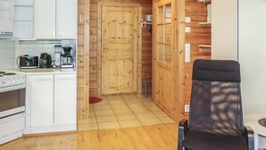 A compact kitchen with white cabinets, a stove, a coffee maker, and a refrigerator. - Taukotuli 4 paritalon alakerta by Interhome (Hyrynsalmi)