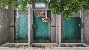 A modern pool area with three separate water sections, each with a glass barrier.
