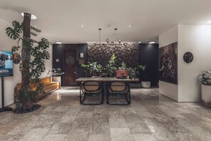 A modern dining area with a wooden table, two chairs, and potted plants. - Monolocale Resort & Spa Seminyak by Ini Vie Hospitality (Keroboken Kelod)