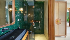 A modern bathroom with a glass shower enclosure, a wooden vanity, and a large mirror. - Monolocale Resort & Spa Seminyak by Ini Vie Hospitality (Keroboken Kelod)