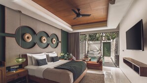 A modern bedroom with a bed, bedside tables, a TV, and a view of a pool. - Monolocale Resort & Spa Seminyak by Ini Vie Hospitality (Keroboken Kelod)