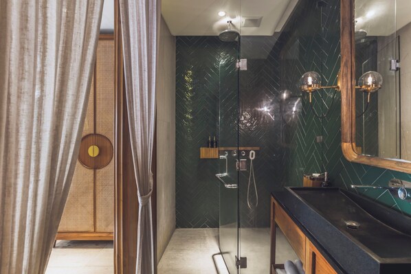 Une salle de bain moderne avec une douche à parois de verre, un meuble-lavabo en bois et un grand miroir.