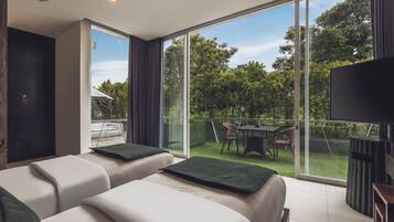 Une chambre d’hôtel moderne avec deux lits, une télévision et un balcon équipé d’une table et de chaises.