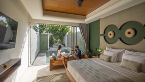 A modern bedroom with a large bed, a ceiling fan, and a view of a swimming pool. - Monolocale Resort & Spa Seminyak by Ini Vie Hospitality (Keroboken Kelod)