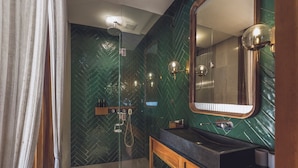 A modern bathroom with a glass-enclosed shower, a wooden vanity, and a large mirror. - Monolocale Resort & Spa Seminyak by Ini Vie Hospitality (Keroboken Kelod)