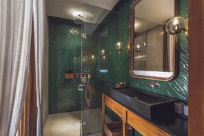 A modern bathroom with a glass-enclosed shower, a wooden vanity, and a large mirror. - Monolocale Resort & Spa Seminyak by Ini Vie Hospitality (Keroboken Kelod)
