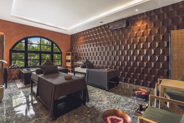 A modern room with a large arched window, a wall with a geometric pattern, and a seating area with a table and chairs. - Monolocale Resort & Spa Seminyak by Ini Vie Hospitality (Keroboken Kelod)