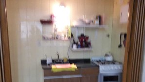 Una cocina con gabinetes de madera, estufa a gas y microondas.