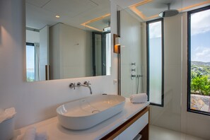 Ein modernes Badezimmer mit einem großen, ovalen Waschbecken, einem Spiegel und einer Dusche.
