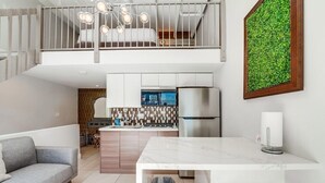 Eine moderne Wohnung mit Küche, Essbereich und Schlafgalerie.