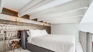 Ein modernes Schlafzimmer mit einem Bett, einem kleinen Tisch und einem Stuhl.