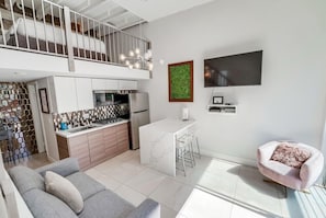 A modern apartment with a kitchen, dining area, and a living room with a sofa. - Bright & Modern 2 Level Unit in heart of Little Italy (San Diego)