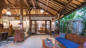 A spacious lobby with a wooden ceiling, a blue sofa, and a wooden table with a plant. - Frida Villa Ubud by Best Deals Asia Hospitality (Ubud)