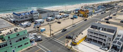 A coastal urban area with a beach, buildings, and a road.