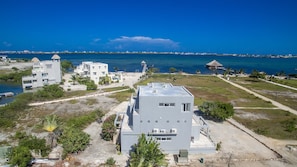 Una propiedad costera con varias construcciones, un muelle y una vista despejada al mar.
