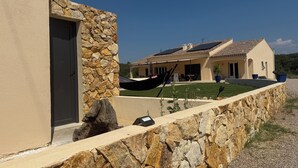 A stone wall with a hammock, a stone door, and a house with a tiled roof. - Provençal farmhouse for 12 people · 10x5 pool · 6 bedrooms/6 bathrooms · Air conditioning (Lorgues)