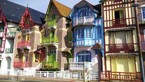 Eine Reihe farbenfroher, historischer Gebäude mit unterschiedlichen Baustilen, darunter Giebel und schmiedeeiserne Balkone.