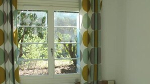 A bedroom with two beds, a window with curtains, and a nightstand with a lamp. - Quiet house between ocean and Bassin d'Arcachon (Cap-Ferret)