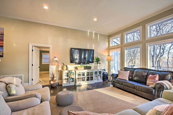 A living room with a fireplace, a large window, and a television. - 10 Mi to New Braunfels: Waterfront Seguin Gem (Seguin)