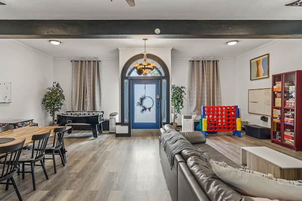 "Spacious entertainment area featuring a pool table, cozy seating with a large TV for streaming, and a stylish dining space. Perfect for relaxing, playing games, or enjoying meals with friends